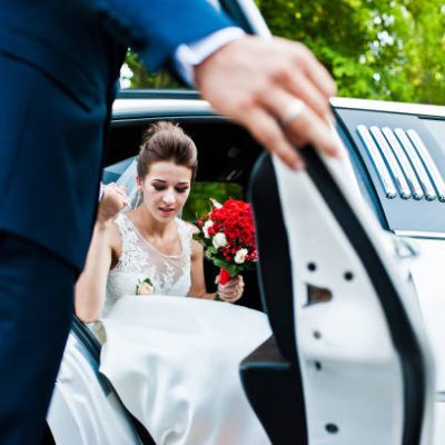 Groom open door of limousine and take hand to bride Groom open door of limousine and take hand to bride